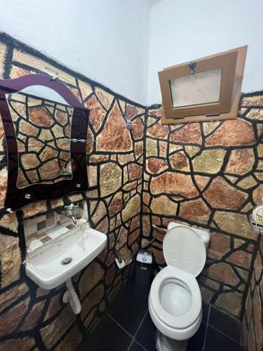 a stone bathroom with a sink and a toilet at Vokopola Villa in Sarandë