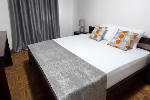 a bedroom with a bed with white sheets and pillows at Casa TIANA in Mindelo