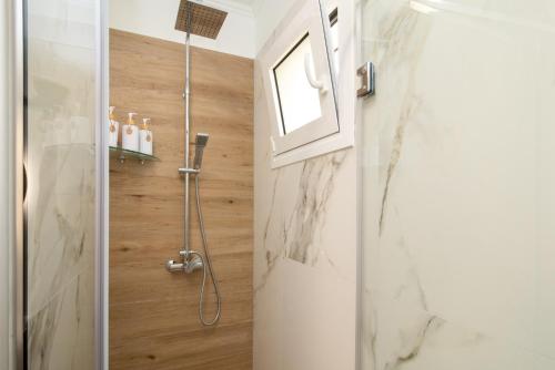 a bathroom with a shower with a glass door at Venetis Family House in Gouvia