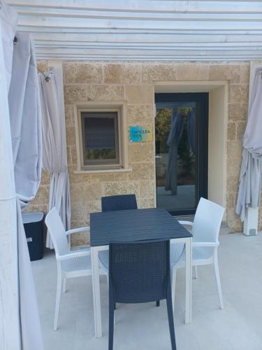 a table and chairs in front of a brick wall at Zeituna Lodge a Porto Cesareo in Torre Lapillo