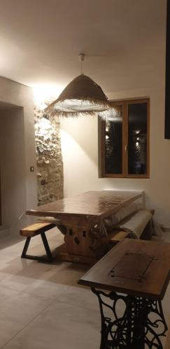 une pièce avec une table en bois et un mur en pierre dans l'établissement Le château, à Annecy