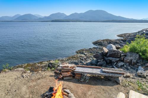 a campfire on the shore of a body of water at 6 Mi to Main St Oceanfront Cottage in Ketchikan in Ketchikan