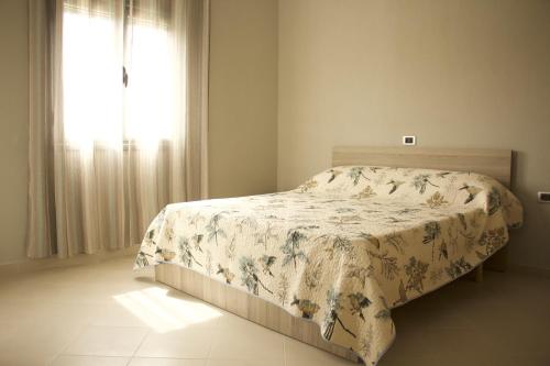 a bedroom with a bed with a floral bedspread and a window at Villa Kozma & Kristina in Zverneci
