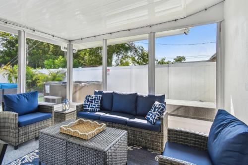 a screened in porch with blue furniture and windows at The Palm Oasis at Clearwater in Clearwater