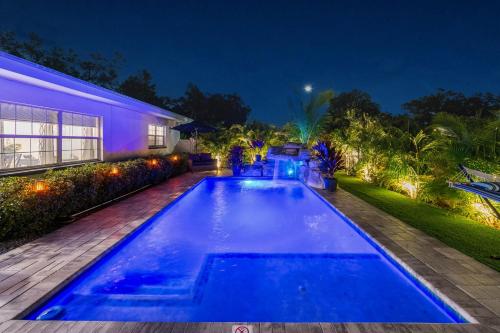 a swimming pool in front of a house at night at The Palm Oasis at Clearwater in Clearwater