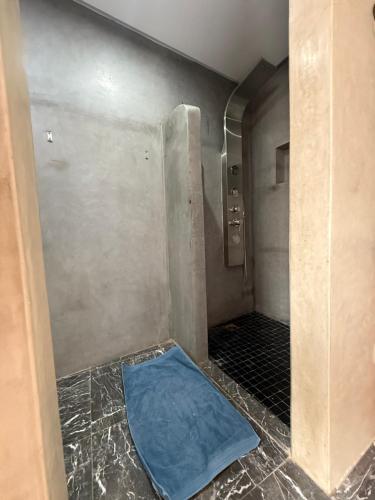 bagno con doccia e tappetino blu sul pavimento di Riad Le Marrakech Berrima a Marrakech