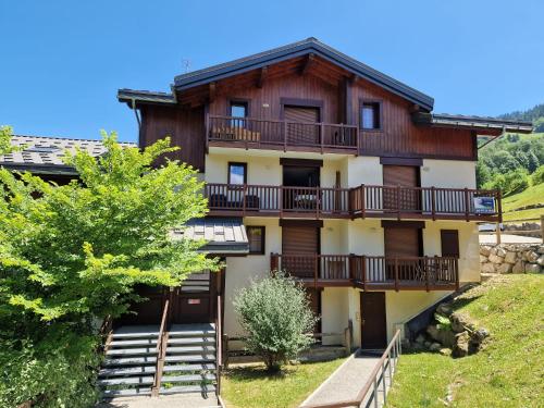 un immeuble avec balcon sur une colline dans l'établissement Chalets des Evettes- appartement vue montagne, à Flumet