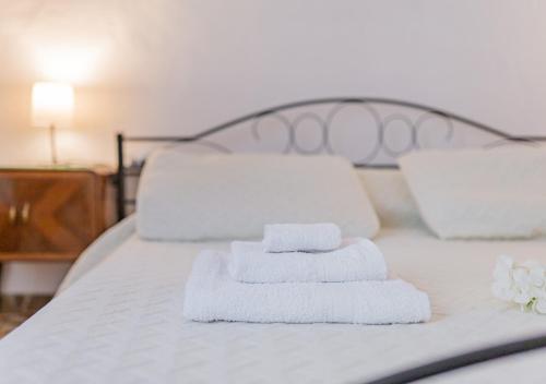 two towels are stacked on a bed with two pillows at Camera tra le Cinque Terre, Camogli e Portofino. Vista valle e scorcio mare all'orizzonte in Castiglione Chiavarese