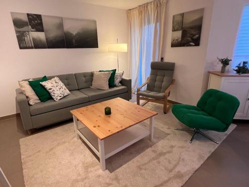 a living room with a couch and a table at Großes Apartment 74m2 mit Balkon & Parkplatz - Steakhouse Esmeralda in Ebersbach-Musbach