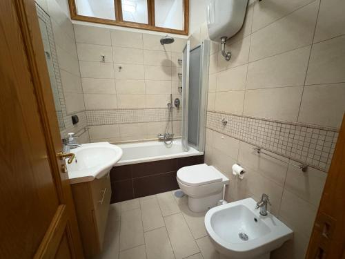 a bathroom with a sink and a toilet and a tub at Central Pompei Rooms in Pompei