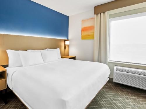 a hotel room with a large bed and a window at Comfort Inn & Suites O'Fallon - St Louis Area in O'Fallon