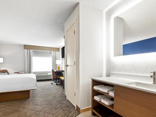 a hotel room with a bed and a sink at Comfort Inn & Suites O'Fallon - St Louis Area in O'Fallon