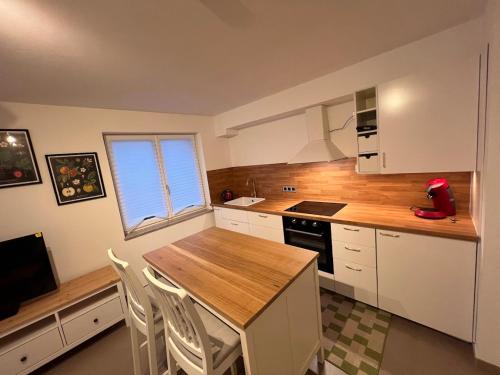 a kitchen with a counter and a table with chairs at Großes Apartment 74m2 mit Balkon & Parkplatz - Steakhouse Esmeralda in Ebersbach-Musbach