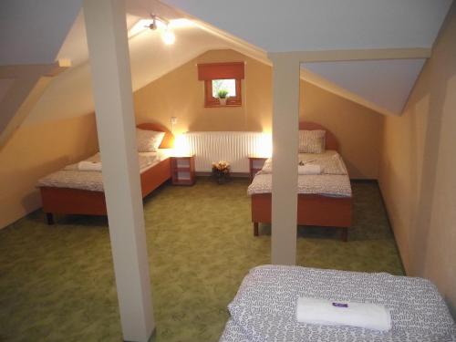 a attic room with two beds in a room at Mediterrán Vendégház in Kecskemét