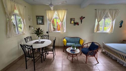 a room with a table and chairs and a bed at Jacoway Inn in Calibishie