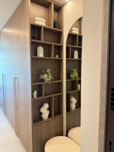 a book shelf in a hallway with vases and plates at Moonlight Apartment - Parko rezidencija SELF CHECK IN in Panevėžys