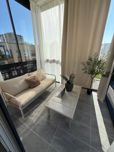 a living room with a couch and a table at Moonlight Apartment - Parko rezidencija SELF CHECK IN in Panevėžys