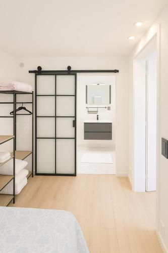 a white room with a kitchen with a sink and a refrigerator at Stylish flat with rooftop in Ixelles in Brussels