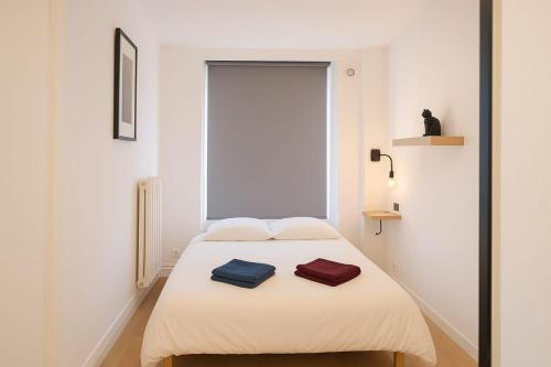 a bedroom with a bed with two towels on it at Stylish flat with rooftop in Ixelles in Brussels
