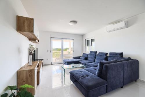 a living room with a blue couch and a table at Vila Baruni in Sukošan