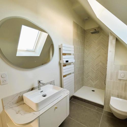 une salle de bain avec un lavabo, des toilettes et un miroir dans l'établissement TI NEVEZ - Elégante Maison en Granit Ploumanach, à Perros-Guirec