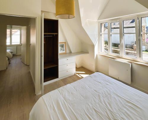 une chambre avec un lit et deux fenêtres dans l'établissement TI NEVEZ - Elégante Maison en Granit Ploumanach, à Perros-Guirec