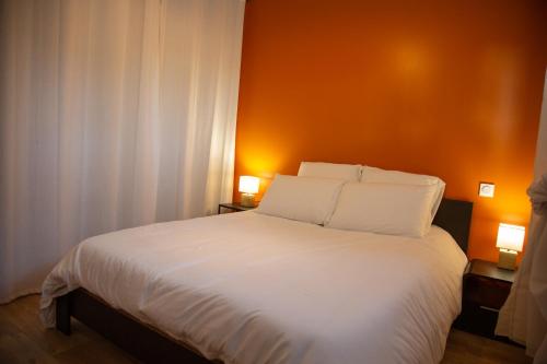 a bedroom with a large white bed with two lamps at La Grange du Hameau in Clion