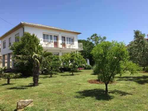 a white house with trees in front of it at Kosovic Family House in Medulin