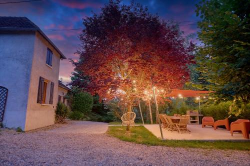 a backyard with a table and chairs and a tree at Le Haut Bois - à 5min du Zoo et centre-ville in Saint-Aignan