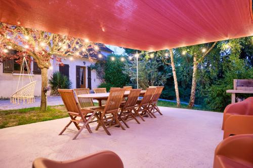 a table and chairs on a patio with lights at Le Haut Bois - à 5min du Zoo et centre-ville in Saint-Aignan