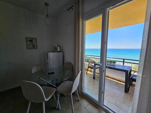 a dining room with a glass table and a view of the ocean at Corfu Dream Holidays Villas in Glyfada