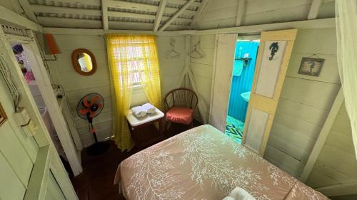a small room with a bed and a table and a window at Jacoway Inn in Calibishie