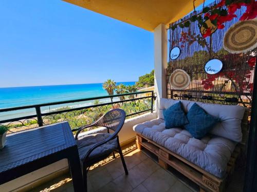 a balcony with a couch and a table and the ocean at Corfu Dream Holidays Villas in Glyfada