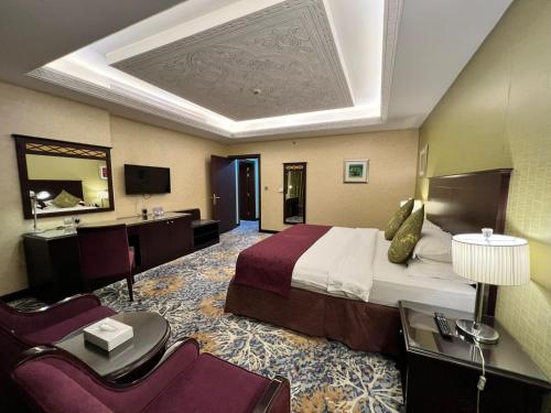 a hotel room with a large bed and a desk at Merkure Jeddah Al Hamraa Hotel in Jeddah
