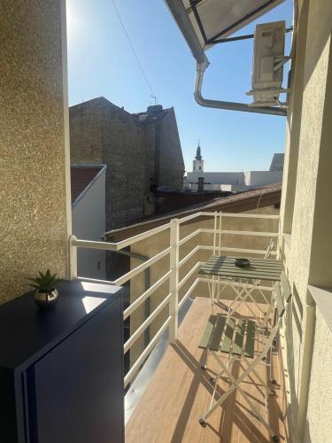 a balcony with a table and a chair on it at Studio Melem in Novi Sad