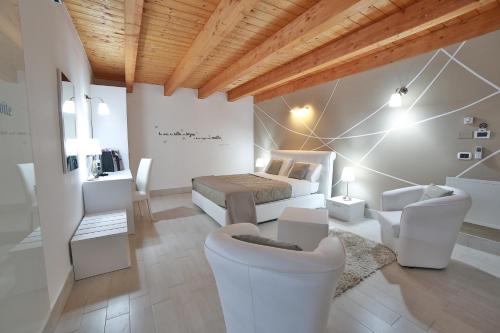 um quarto com uma cama, um sofá e cadeiras em Villa Giulia Del Cavaliere em Castrovillari