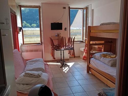 une chambre avec deux lits superposés et un bureau et des fenêtres dans l'établissement STUDIO 2 LUZ SAINT SAUVEUR 4 Personnes, à Luz-Saint-Sauveur