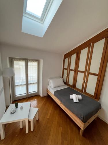 a bedroom with a large bed and a table at Casa di Giò - Comfy Lake Como Attic in Malgrate