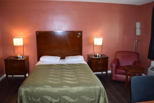 a hotel room with a bed and a chair at Friendship Motor Inn Carneys Point - Pennsville in Cedar Crest Manor