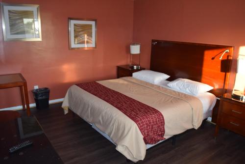 a bedroom with a large bed with a red wall at Friendship Motor Inn Carneys Point - Pennsville in Cedar Crest Manor