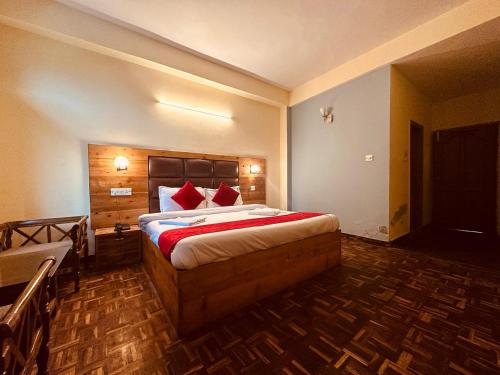 a hotel room with a large bed with red pillows at WooibHotels The Kalinga Grand Manali in Manāli