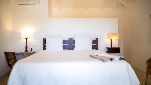 ein Schlafzimmer mit einem weißen Bett und zwei Lampen in der Unterkunft Oceanview Villa With Two Private Pools in Gustavia