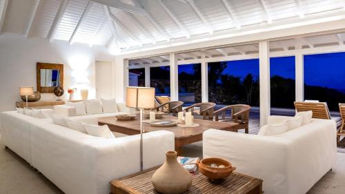 ein Wohnzimmer mit weißen Möbeln und großen Fenstern in der Unterkunft Oceanview Villa With Two Private Pools in Gustavia