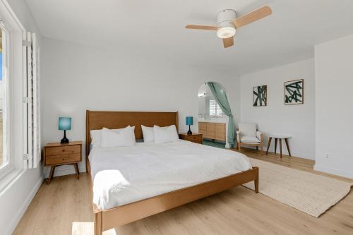 Un dormitorio blanco con una cama y un ventilador de techo. en Burrobrush Terrace, en Joshua Tree