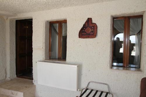 a room with three windows and a chair on a wall at Zen Cappadocia House in Goreme