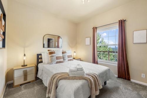 a bedroom with a bed with a mirror and a window at Panorama Peak Mountain Hideaway in Custer