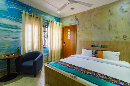 a bedroom with a bed and a chair and a desk at Bays Lodge, Accra in Accra