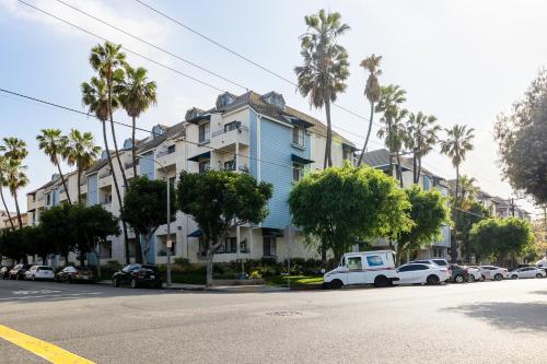 a blue building on a street with palm trees at The Seaside Siesta in Long Beach
