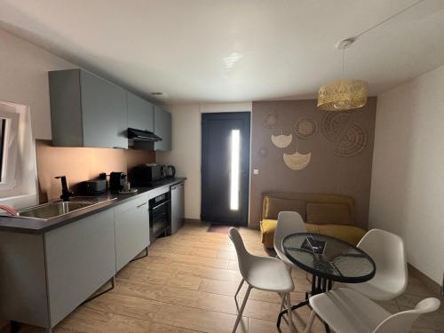 une cuisine et un salon avec une table et des chaises dans l'établissement Studio proche Aéroport de Nantes, à Saint-Aignan-Grand-Lieu