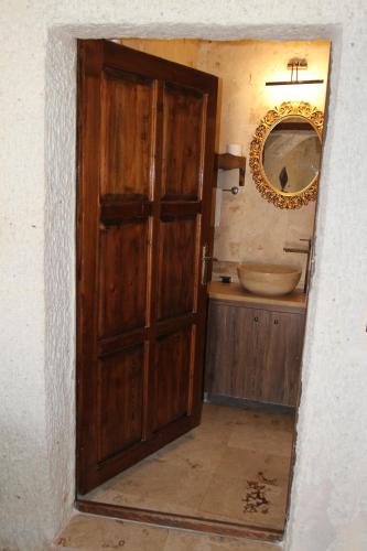 a bathroom with a wooden door and a sink at Zen Cappadocia House in Goreme